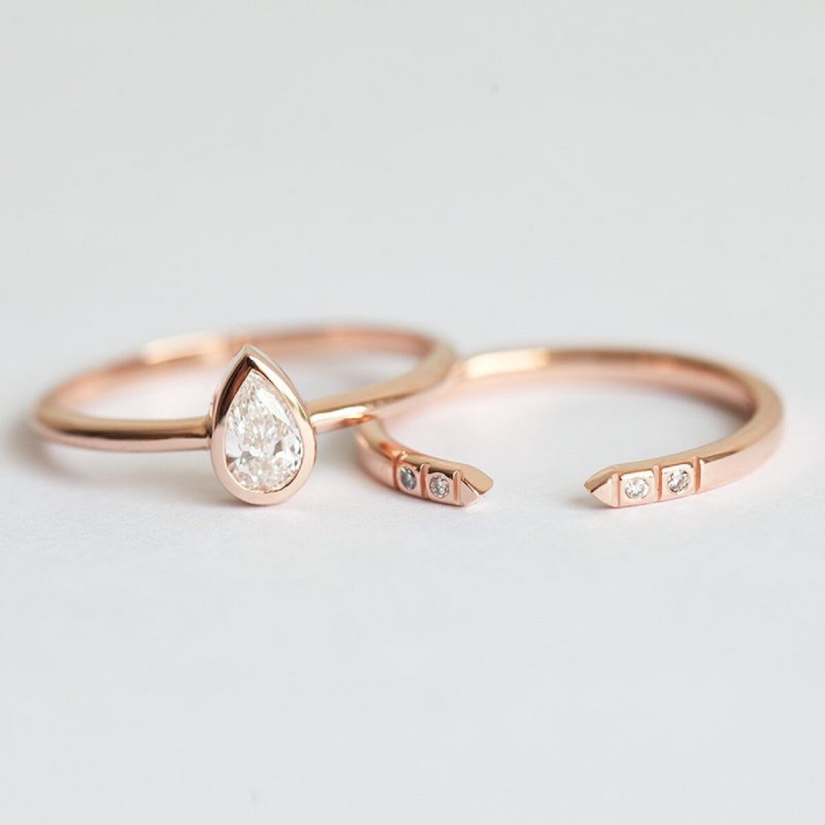 Minimal style pear cut lab grown diamond ring with pave set open gap wedding band crafted in solid 14k rose gold.