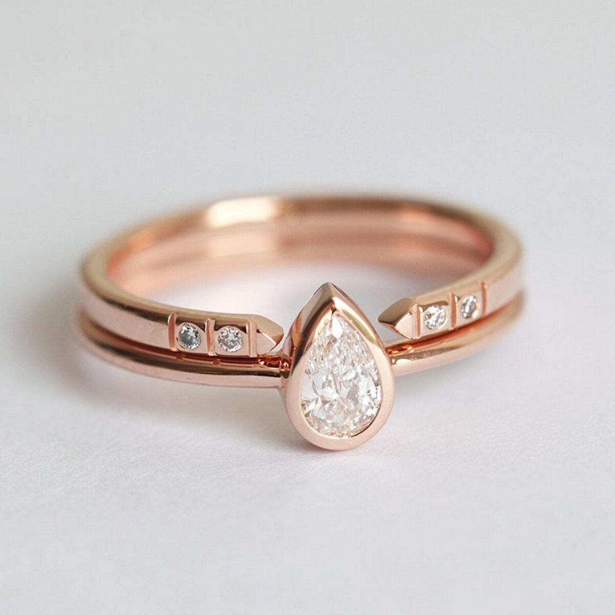 Minimal style pear cut lab grown diamond ring with pave set open gap wedding band crafted in solid 14k rose gold.