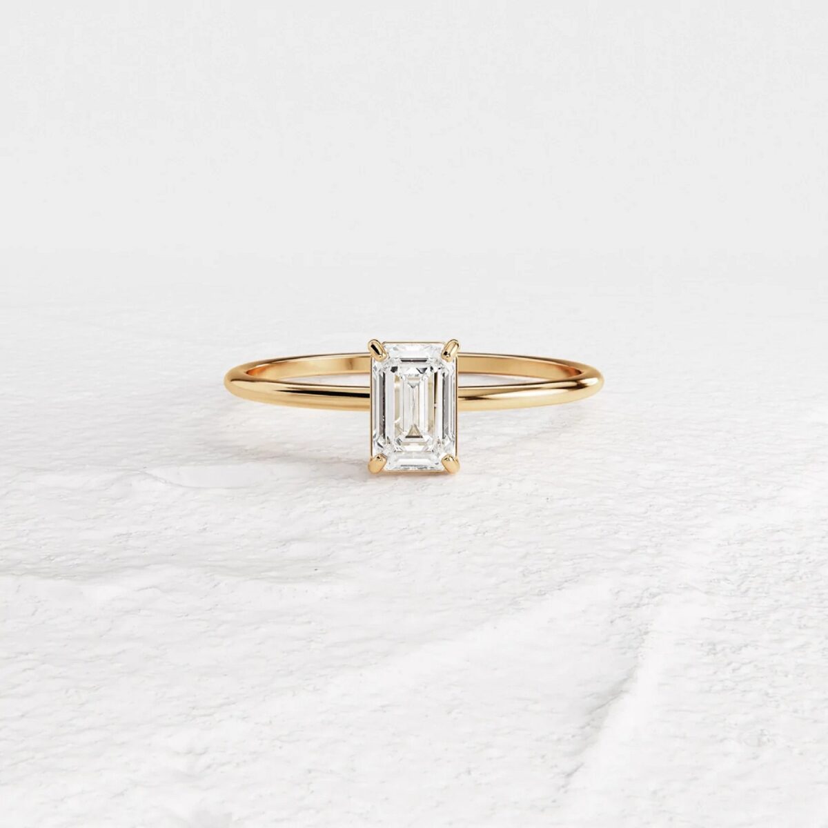 Classic emerald cut lab grown diamond solitaire ring crafted in 14k yellow gold.