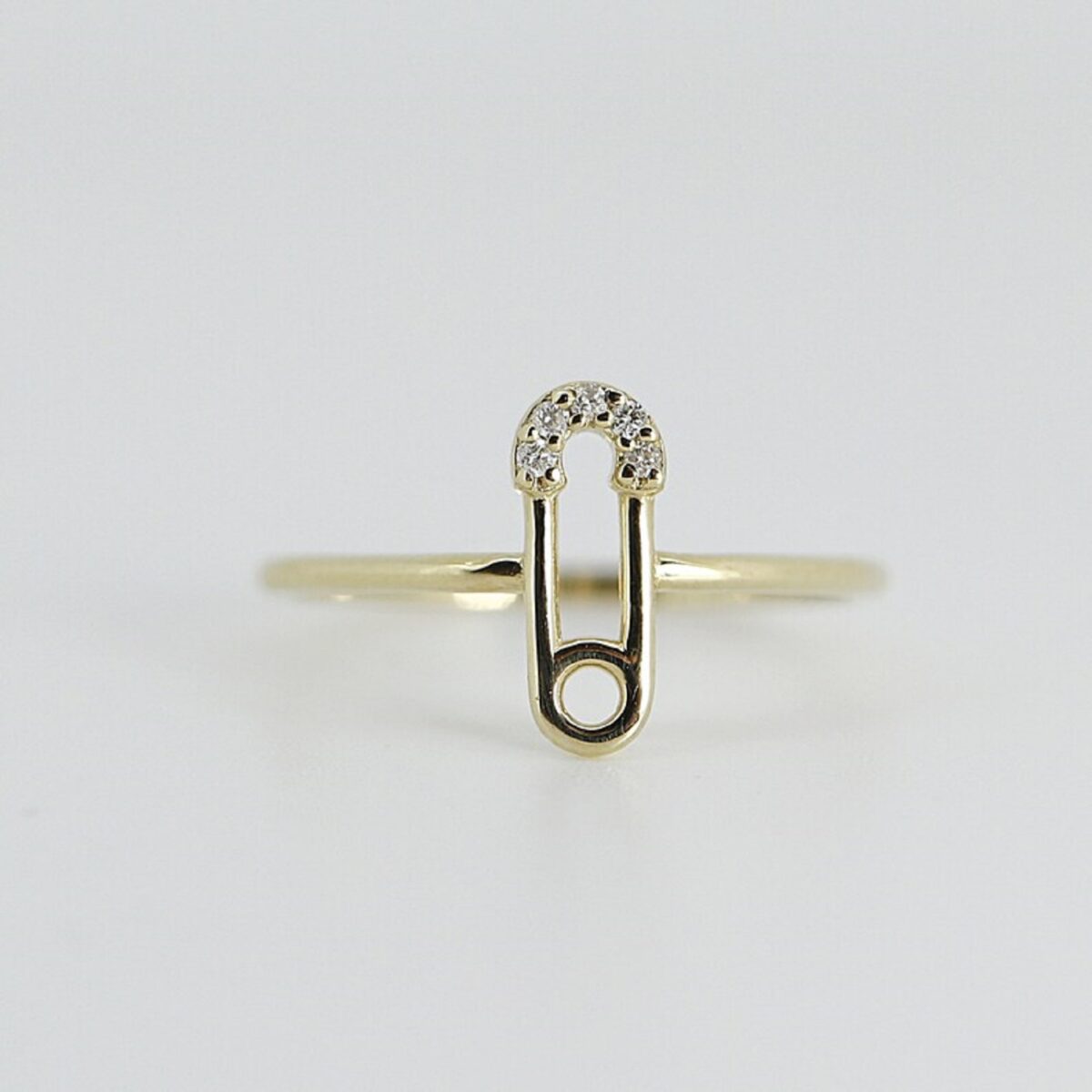 Unique, modern, minimal, safety pin shaped round cut lab grown diamond ring crafted in 14k solid yellow gold