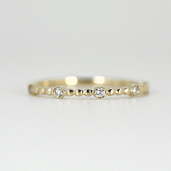 Unique round cut lab grown diamond stacking that milgrain setting around diamond and set between gold bead. This crafted in 14k yellow gold.