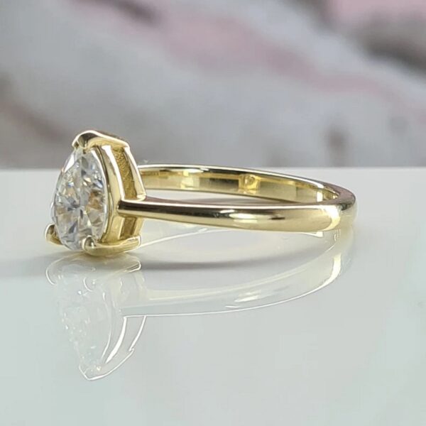 Minimal teardrop pear lab grown diamond ring for bridal crafted in 14k yellow gold..