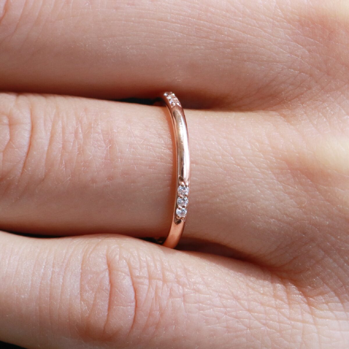 Round cut tiny lab grown diamond wedding band crafted in 14k white gold.