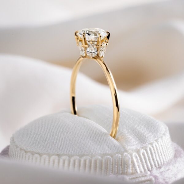 Round cut lab grown diamond with accent pear cut hidden halo engagement ring crafted in 14k yellow gold.