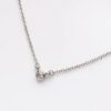 Tiny bezel set round cut lab grown diamond charm pendant is crafted in 14k white gold.